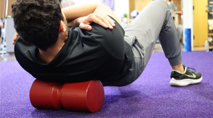 Person lying over a Back Trac foam roll to unload the spine